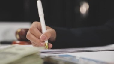 İş kadını, masasında para, iş konsepti ve ofis olan kalemle el ele tutuşur.