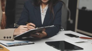 Ofiste iş planı tartışılırken iş kadınlarının ellerini tablet ve kalem kullanarak kapat