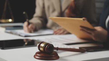 Avukat, yargıç ve müvekkil mahkeme salonunda belgelerle çalışıyor.