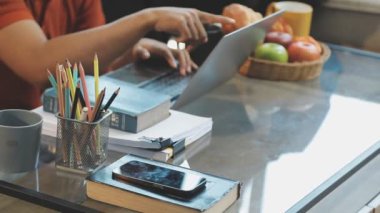 Kafede tablet bilgisayar kullanan genç Asyalı kadın.