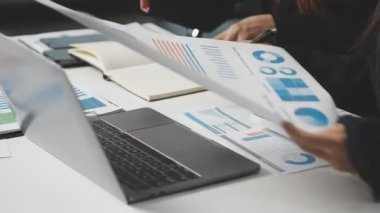 Ofisteki verileri hesaplamak için hesap makinesi kullanan işadamlarının görünümünü kapat.