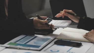 Dijital hesap makinesi ve dizüstü bilgisayarlı kalem kullanarak iş adamının elini kapat