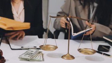 Avukat ve kadın büroda yasal belgeleri ve adalet belgelerini tartışıyorlar. Avukat ve yargıç hukuk ve adalet belgeleriyle çalışıyor.