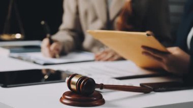 Yargıç Tokmak ve işadamı ofisindeki tahta masada belgelerle çalışıyorlar.