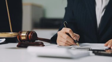 Avukatlar, avukatlar, avukatlar ya da avukatlar bürodaki ahşap masada bir belge ve yasal bir belge üzerinde çalışıyorlar. Hukuk hizmetleri, hukuki adalet