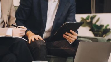 Kafede bir tableti ve kalemi olan genç bir işadamı.