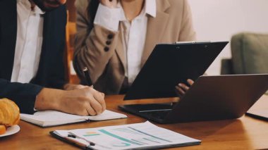 Genç işadamı kahvaltı yaparken dizüstü bilgisayar kullanıyor.