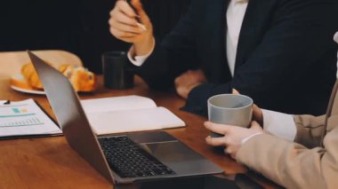 Modern kafede iş adamları tartışıyor ve çalışıyor.