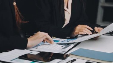 Yakın plan - ofiste dizüstü bilgisayarda çalışan iş kadınlarının elleri.