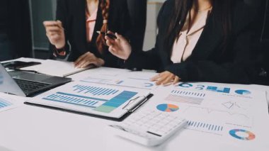 Ofiste dizüstü bilgisayarda finansal grafikle çalışan iş adamları