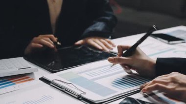 Ofisteki masada dijital tablet ve mali veri kullanan işadamı