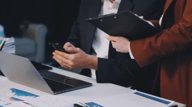 İş yerinde dizüstü bilgisayarı ve kalemi olan takım elbiseli genç işadamı.