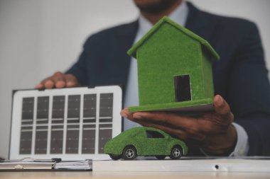 Müzayedeci, emlak satışını örnek ev ve avukat tokmağıyla yıkıyor. Yargıç, mahkeme arabasının hakiminin tokmağında emlak alım satımında arabuluculuk yapıyor.