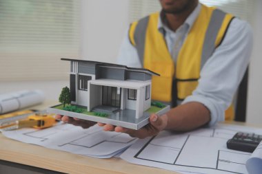 Mimarlar, mühendisler, müteahhitler ofiste planlar, teftiş mühendisleri mimari plan analizi, inşaat projesi taslağı, odaklanma, iş inşaatı konsepti ile çalışıyorlar..