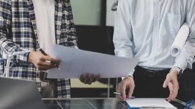 Planı elinde tutan genç işadamının yakın görüntüsü ve yeni planın grafiğine işaret ediyor. modern ofis binası