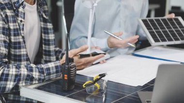 Güneş enerjisi. Erkek mühendis güneş enerjisi istasyonunda güneş paneli ile güneş paneli üzerinde çalışıyor. Güneş paneli tutan ve güneş enerjisini kontrol eden adam.