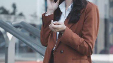 İş kadını açık ofiste akıllı telefon kullanıyor.