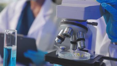 Test tüpünü sıvı ile tutan kadın bilim adamının yakın çekimi.