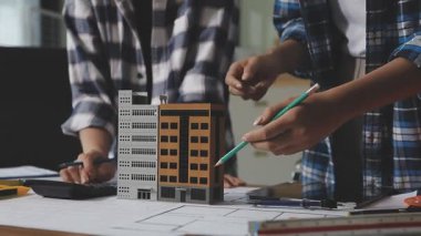Emlak mühendisi ofiste ev planıyla çalışıyor, inşaat, emlak işi konsepti.
