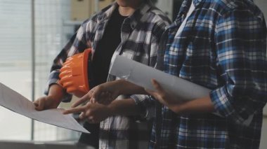 Mühendis elinde planlı bir ofis planı tutuyor. İnşaat mühendisliği ve inşaat konsepti.