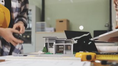 Genç kadın mühendis ofiste inşaat projesinde çalışıyor.