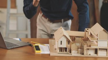 Evdeki planlarla çalışan mühendis.