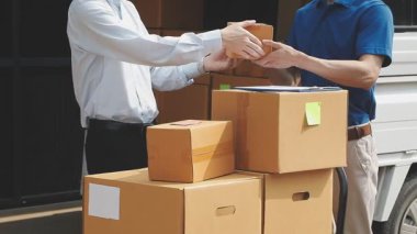 Depoda karton kutuları olan üniformalı bir adam.