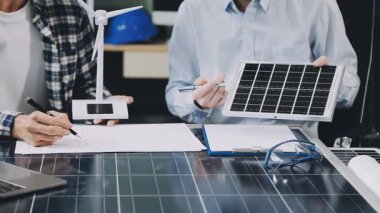 Kadın ve erkek güneş paneli tutuyorlar.