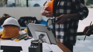 Tablet ve akıllı telefonla bilgisayarda çalışan genç adam