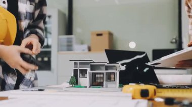 Genç bayan mühendis yeni ev planı üzerinde çalışıyor. İnşaat endüstrisi konsepti.