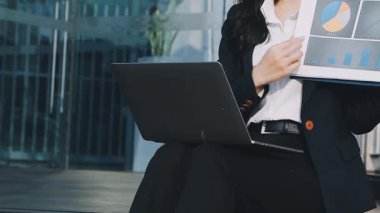 İş kadını elinde dizüstü bilgisayar tutuyor.