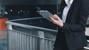 Şehir caddesinde tablet bilgisayar kullanan genç iş kadını, kapatın, iş kadını dijital tablet üzerinde çalışıyor, tablet kullanıyor.