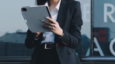 İş kadını şehirde dikilirken akıllı telefon kullanıyor