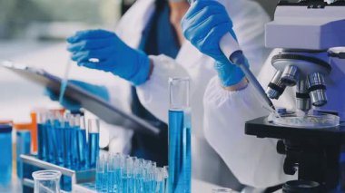 Laboratuvarda deney tüpüyle çalışan bilim adamı..