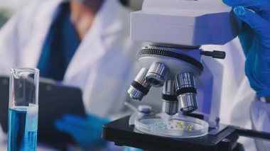 Laboratuvar asistanı bir kimya laboratuarının elinde deney tüpü tutuyor..