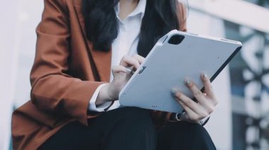 Tablet kullanan günlük kıyafetli genç bir kadın.