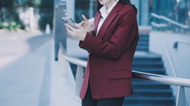 Resmi olarak Asyalı kadınlar iş için akıllı telefon kullanır ve ofis, iş ve mali konseptlerde çalışır.,