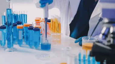 Kapat. Pipetli laboratuar asistanı.