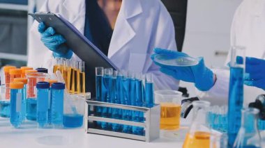 Laboratuvarda test tüpleri tutan bir bilim adamının yakın plan fotoğrafı..