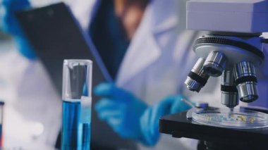 Laboratuvarda mikroskopla inceleyen bilim adamları