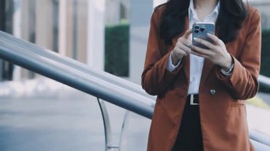 İş kadını şehirde cep telefonu kullanıyor.