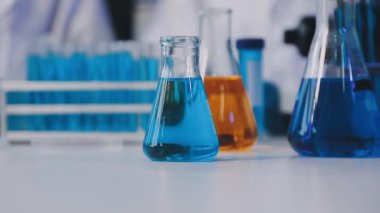 Laboratuvar cam ve mavi sıvı kimya laboratuarındaki masada.
