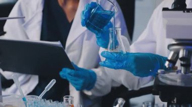 Laboratuvarda kimyasal çözeltisi olan sıvı tüpü tutan bilim adamı.