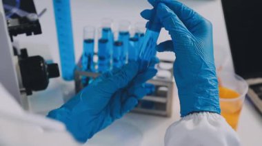 Laboratuvarda çalışan koruyucu eldivenli ve gözlüklü bilim adamlarına yaklaş.