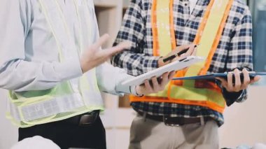 Mühendis ve mimar ekibi arka planda planla birlikte çalışıyor..