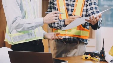 Mühendis ve mühendis ekibi inşaat projesini tartışıyor ve planlıyor. İnşaat mühendisi ekibi inşaat alanında birlikte çalışıyor.