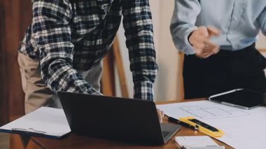 Genç mimar dizüstü bilgisayarında plan ve planla çalışıyor..