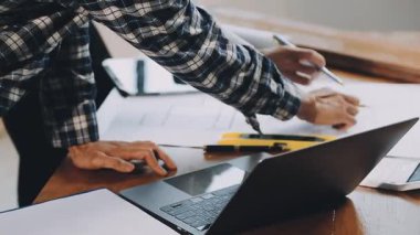 Genç işadamı, dizüstü bilgisayar ve not defteri kullanarak ofiste çalışıyor..