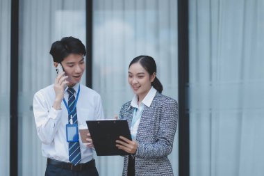 Ofisteki iş arkadaşları ofis binasının dışında yeni projeleri tartışıyor, dijital tablet tutuyorlar. Ofis binalarının önünde duran iki iş arkadaşı iş planını tartışıyor.