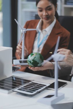 kadın alternatif enerji mühendisi bir yel değirmeni güç örnek model tutun ve stüdyoda alternatif güç kaynağı için onun erkek arkadaşı ile tartışmak